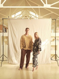 a man and woman posing in front of a white backdrop