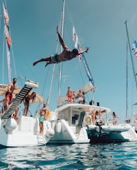 a man jumping off a boat in front of a crowd of people