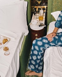 a woman in a blue pajama sitting on a bed