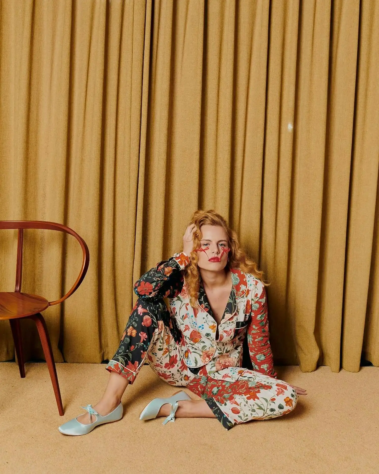 a woman sitting on the floor in a floral pajama suit