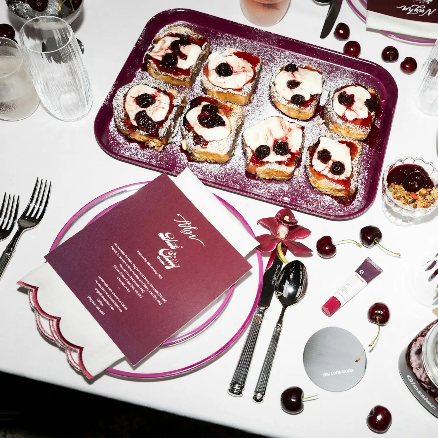 a table is set with a plate of food and a glass of wine