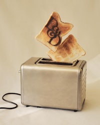 a toaster with two slices of bread flying out of it