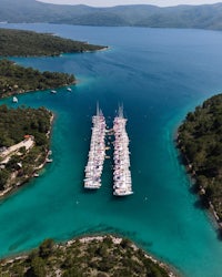 an aerial view of several boats docked in the water